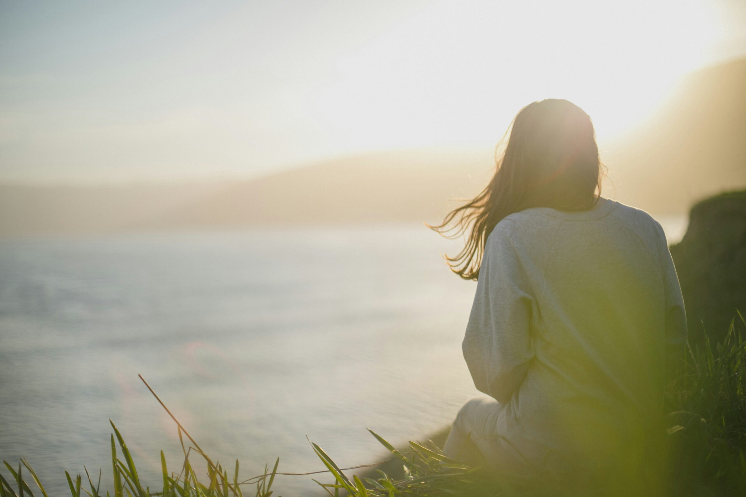 Woman relaxing near the ocean with sunlight flooding in