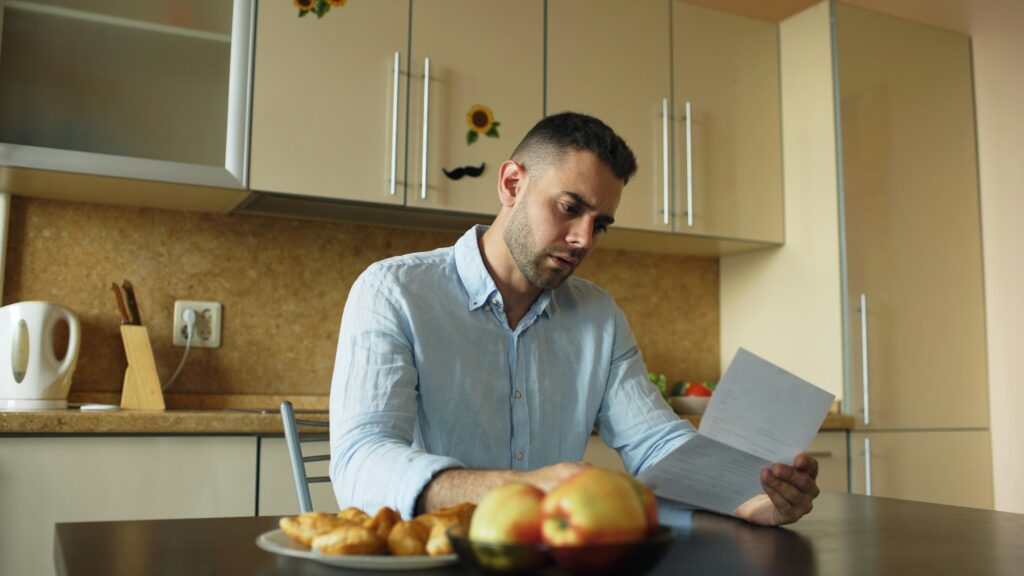 Man reviewing semen analysis results at home, considering integrative fertility options