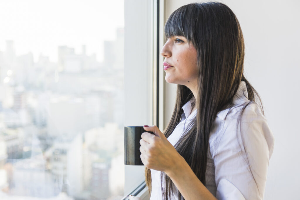 Woman looking out window contemplating Ozempic side effects
