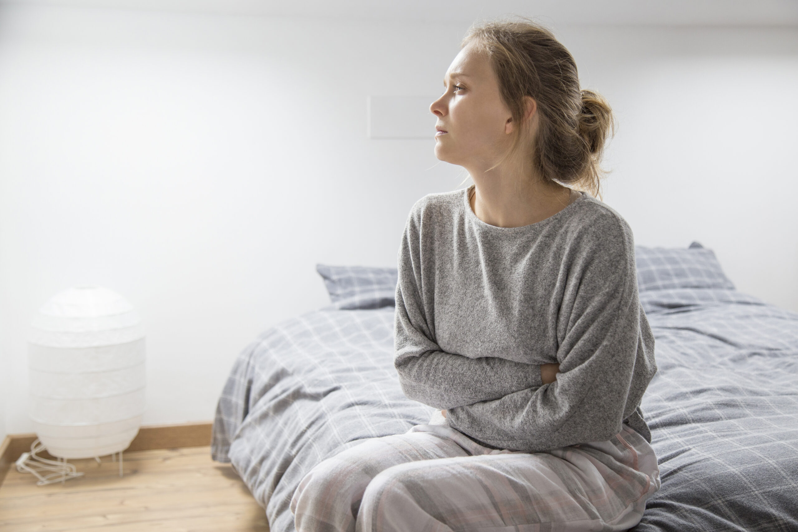 Woman experiencing ongoing bloating and fatigue weeks after a stomach bug